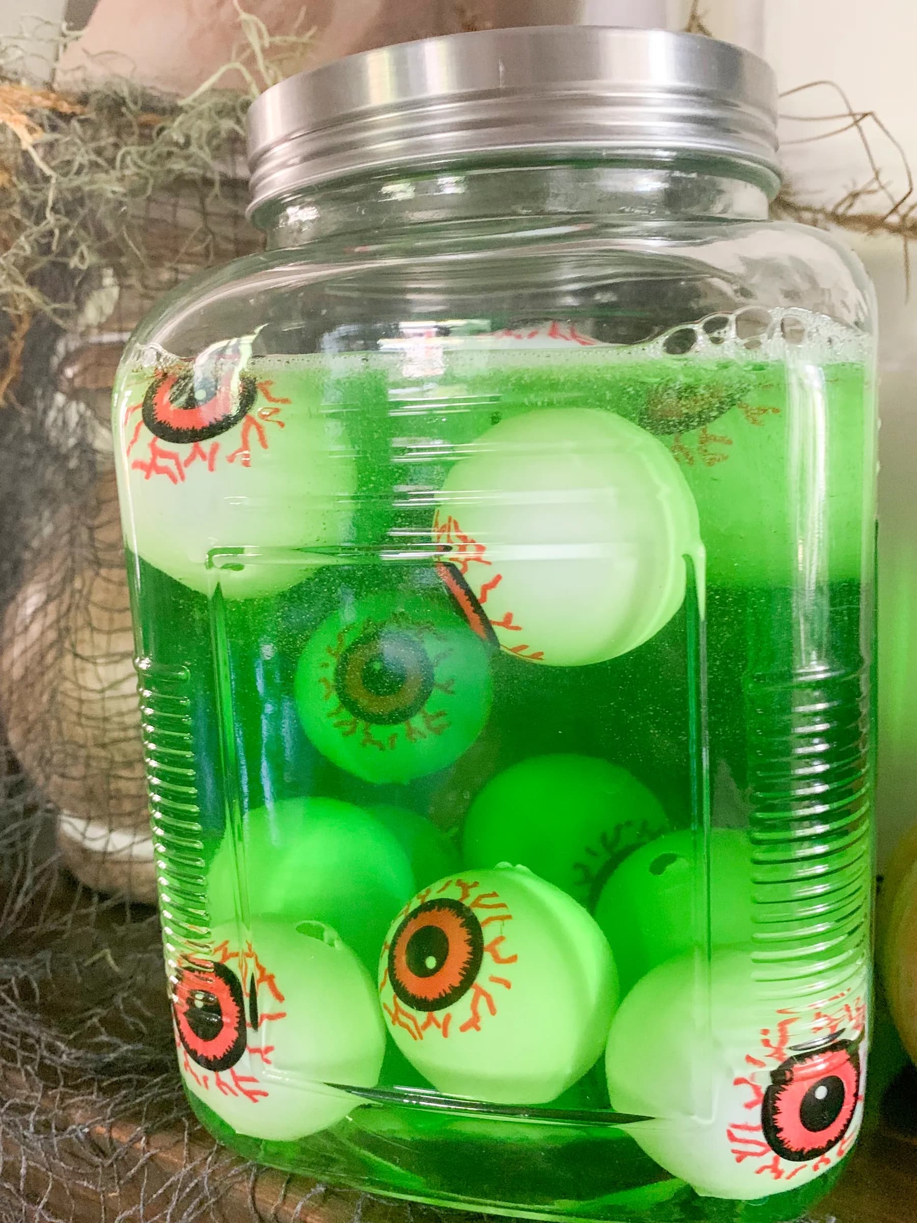 Mad Scientist Jar DIY Mad Scientist Jars. Glass jars filled with colorful liquids, dry ice, and Halloween props arranged on dark surface. Halloween Decoration.
