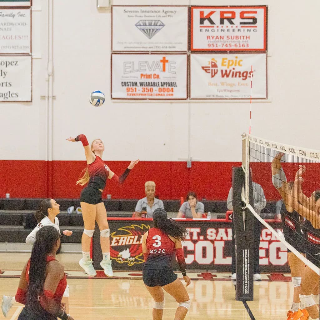 Mt. San Jacinto College outside hitter Daija Malcolm (#12) executes a spike at the net against Chaffey College defenders. Photo by Lisa Zambrano