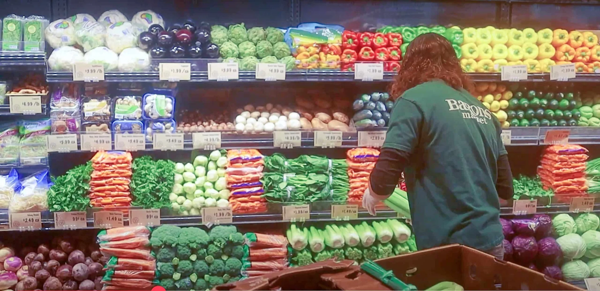 An employee stocks Produce at Barons Market