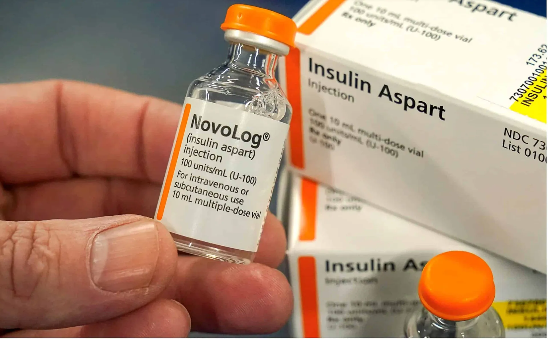 person holding a vial of insulin