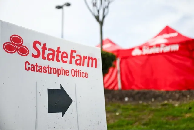 State Farm won conditional approval for homeowners insurance rate hikes averaging 22% in California. The company's logo is displayed on a sign near a mobile catastrophe office following wildfires that destroyed thousands of homes in Los Angeles on Feb. 21, 2025. Credit: Photo by Patrick T. Fallon, Getty Images