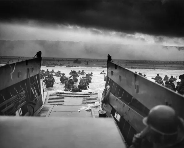 A LCVP (Landing Craft, Vehicle, Personnel) from the U.S. Coast Guard-manned USS Samuel Chase disembarks troops of Company A, 16th Infantry, 1st Infantry Division (the Big Red One) wading onto the Fox Green section of Omaha Beach (Calvados, Basse-Normandie, France) on the morning of June 6, 1944. American soldiers encountered the newly formed German 352nd Division when landing. During the initial landing two-thirds of Company E became casualties. Credit: Chief Photographer's Mate (CPHoM) Robert F. Sargent
