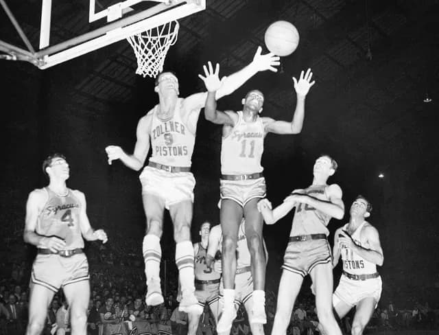 October 31. Fort Wayne's Mel Hutchins (9) and Syracuse's Earl Lloyd (11) reach for the ball during an NBA basketball game in Indianapolis, April 1955 Credit: AP