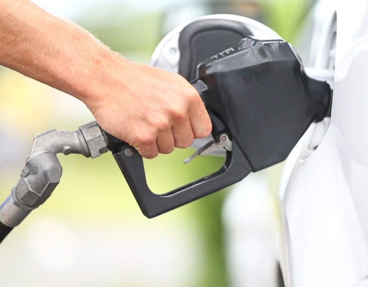 A hand on a gas pump in a car