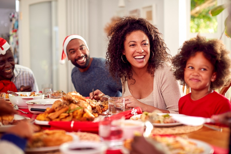 A family eating a hiliday dinner. Host the Holidays Affordably