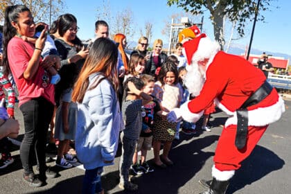 Santa Claus played by Shawn Keebaugh greets children on Christmas Day at the Cowboys 4 A Cause event in Norco.