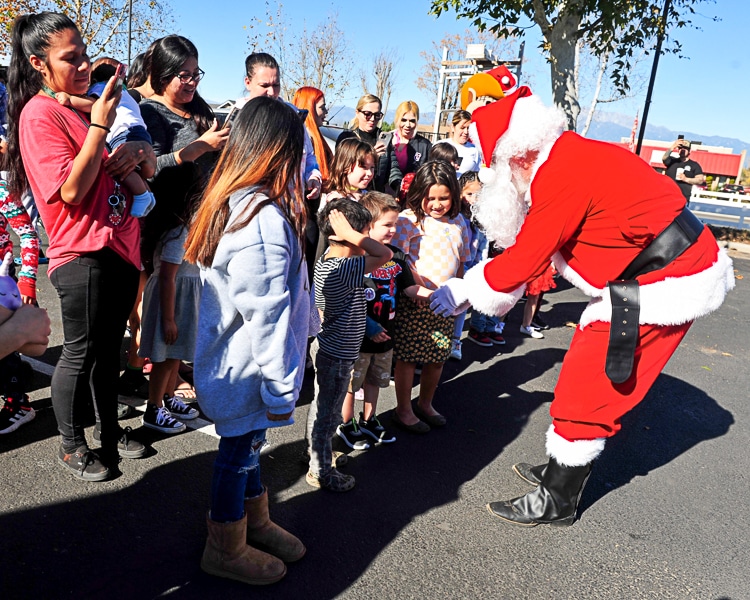 Santa Claus played by Shawn Keebaugh greets children on Christmas Day at the Cowboys 4 A Cause event in Norco.