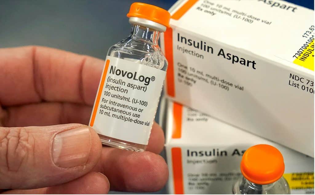 person holding a vial of insulin
