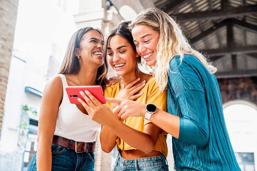 3 women looking at a phone