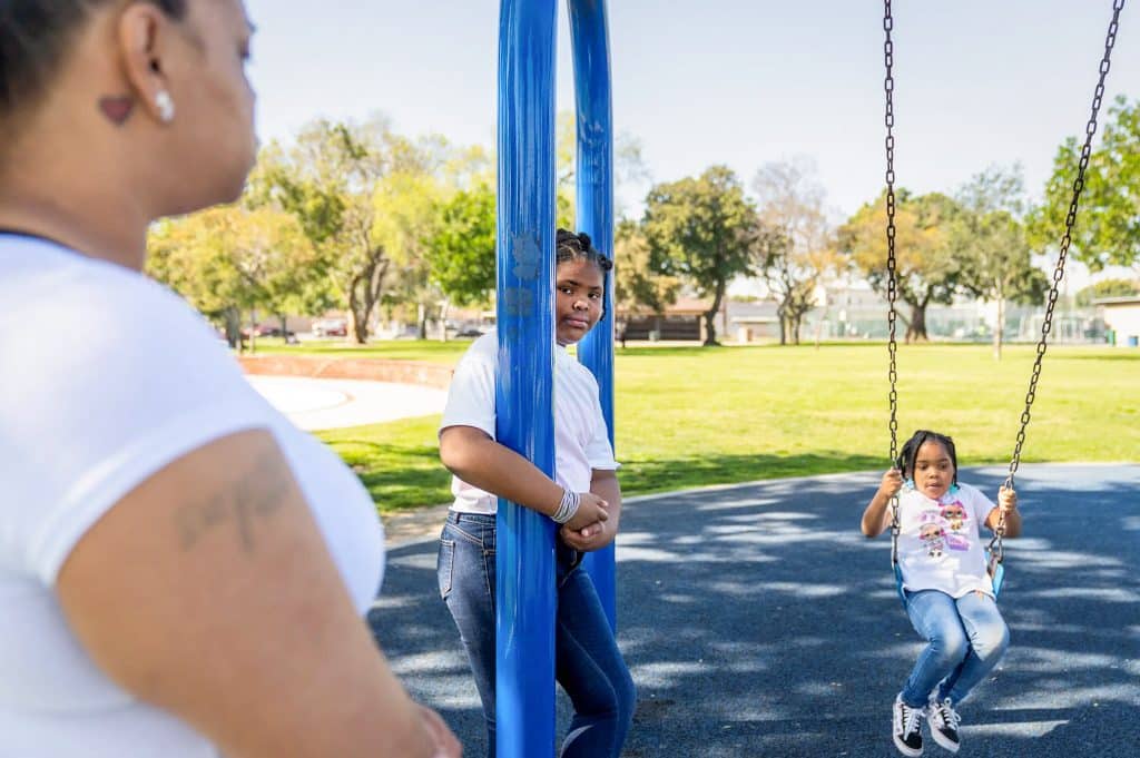 Anneisha Williams at a park with her daughters Kamaya, 9, and Nevaeh, 6, in El Segundo on Feb. 20, 2023. Credit: Photo by Lauren Justice for CalMatters
