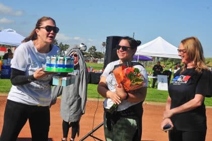 100 Mile Club Founder Kara Lubin holds a 30th birthday cake as she celebrates her organization's birthday with club leaders National Program Specialist Michelle Toulmin (middle) and Brand & Marketing Manager Karina Villaseñor (right). About 500 people took part, seeking to raise $25,000 to benefit the non-profit which promotes fitness for youngsters to seniors.