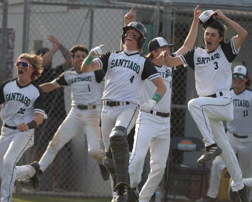 Corona Santiago baseball players celebrate walk-off home run by Ethan Monroe that defeats Santa Ana Mater Dei, 6-5, in the bottom of the seventh inning. Credit: Photo by Jerry Soifer