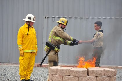 Corona Observes Flag Day. Boy Scout Isaiah Wilson, 12, hands Corona firefighter Alex Schwerber an American flag to be burned at a Flag Day ceremony at the Corona Fire Training Center Saturday. Credit: Photo by Jerry Soifer