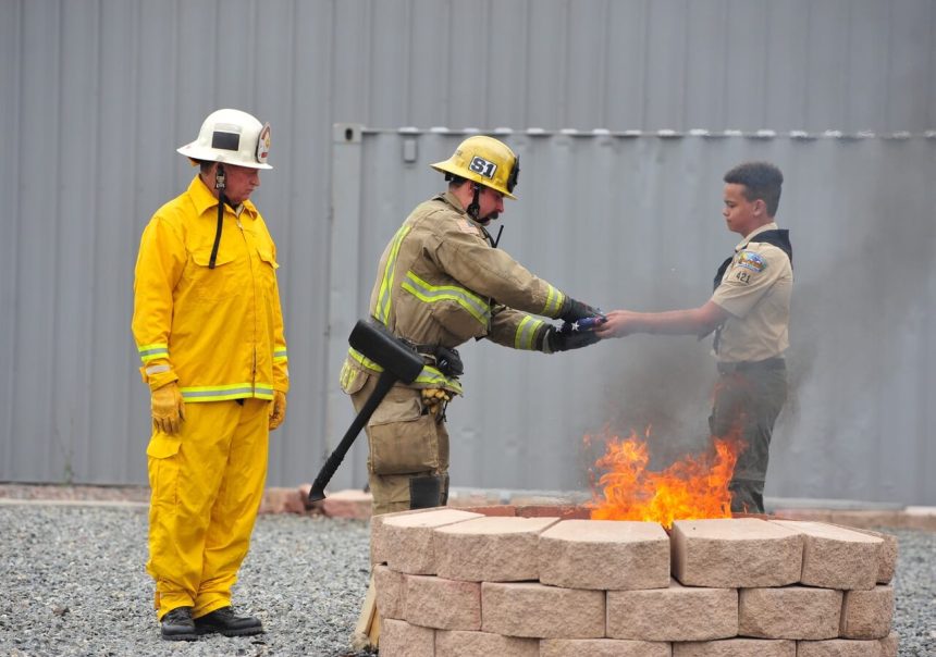 Corona Observes Flag Day. Boy Scout Isaiah Wilson, 12, hands Corona firefighter Alex Schwerber an American flag to be burned at a Flag Day ceremony at the Corona Fire Training Center Saturday. Credit: Photo by Jerry Soifer