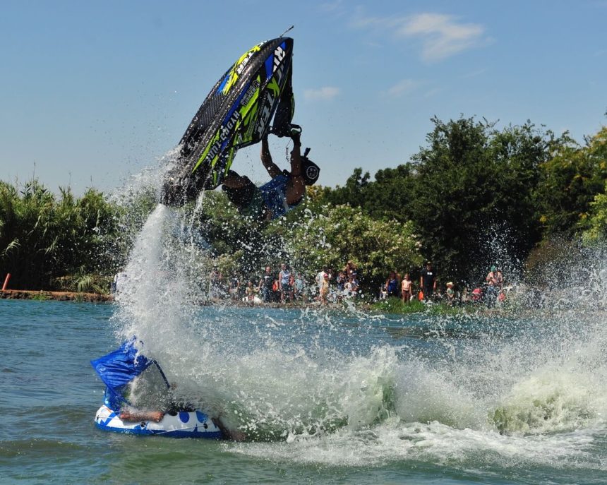 Mark Gomez, of Lake Havasu, flies through the air on a jet ski Saturday during an exhibition at the Youth Outdoor Adventure event at Mike Raahauge Shooting Enterprises near Eastvale. Fred Baskin, of Carrollton, Ga., is in the boat beneath Gomez. More event photos on P6. Credit: Photo by Jerry Soifer