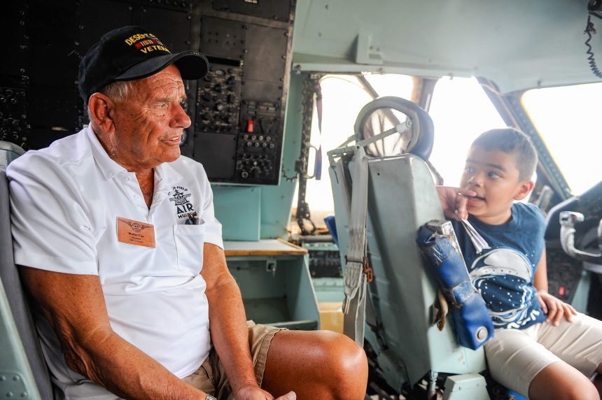 March Airfare Base Open House. Retired U.S. Air Force pilot Walter Fus, a Moreno Valley resident sits in the cockpit of a C-141 transport plane and talks to Bernado Swaby, 10, of Diamond Bar, during an open house at the March Air Museum on Saturday. The C-141 was one of the planes open to be toured by the hundreds of people who turned out for the event.