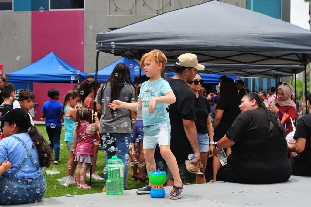 Local Schoolchildren  Five-year-old Hayden Hunter is awash in bubbles as one of more than 2-thousand schoolkids who attended the Leela Project Barbers & Backpacks back-to-school event in Corona.