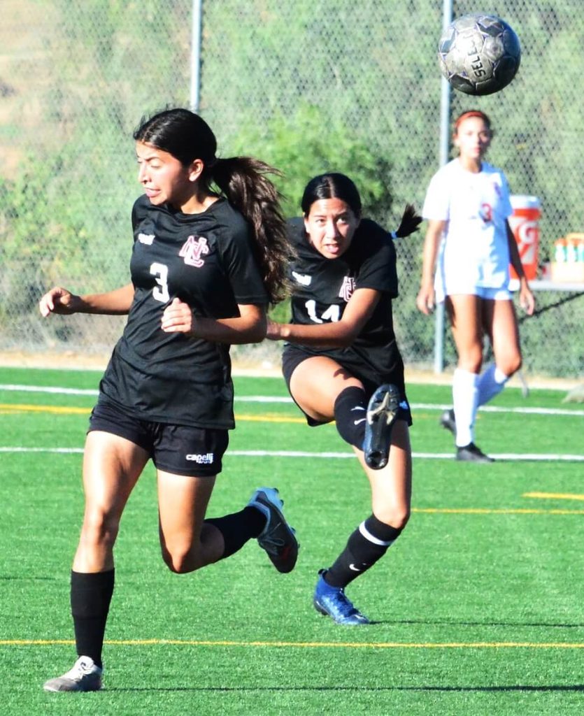 Norco College’s Sabrina Bains (3) clears out of the way as teammate Julianna Duenas (14) sends a free kick downfield during the Mustangs 1 – 0 loss to Orange Coast College. 
Credit: Phot by Gary Evans
