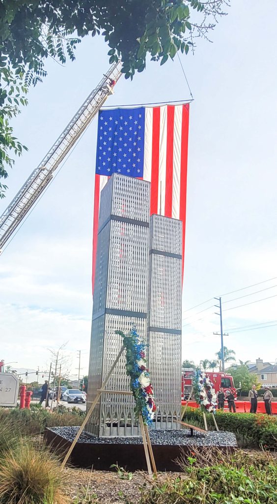 Anniversary of 9/11. A Memorial of the World Trade Center Twin Towers located in front of Eastvale Fire Station 27 is framed by an enormous American Flag held aloft by the station’s hook and ladder rig this past Monday 9/11/23. others killed in the terrorist attacks on September 11, 2001. Credit: Photo by Gary Evans