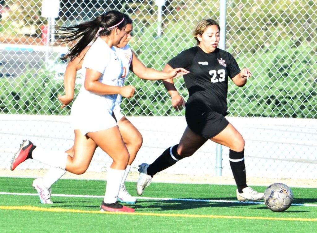 Norco College’s Kaitlyn Sagastume (23) makes her way past two Pirate defenders during the Mustangs 1 – 0 loss to Orange Coast College. 
Credit: Photo by Gary Evans
