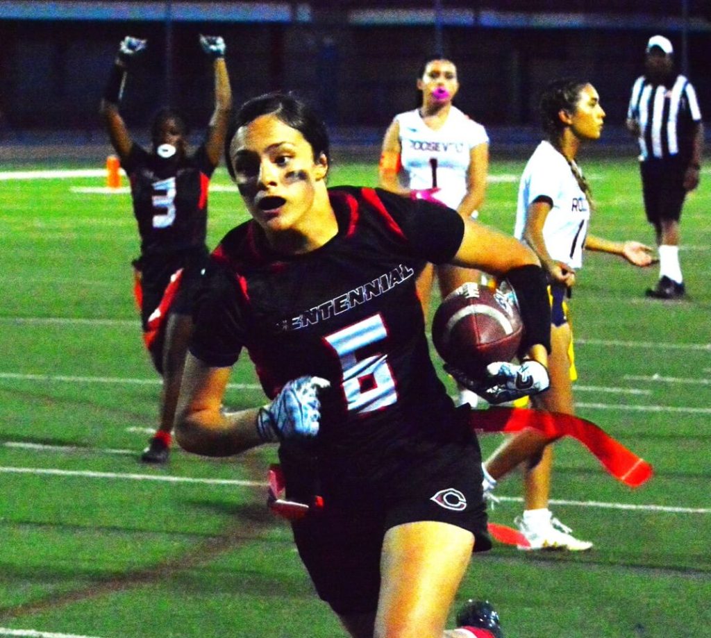 While Corona Centennial’s Zion Howard (3) celebrates, Viviana Anguiano (6) scores a touchdown against Eastvale Roosevelt.  The Huskies defeated the Mustangs 26 – 19.
Credit: Photo by Gary Evans
