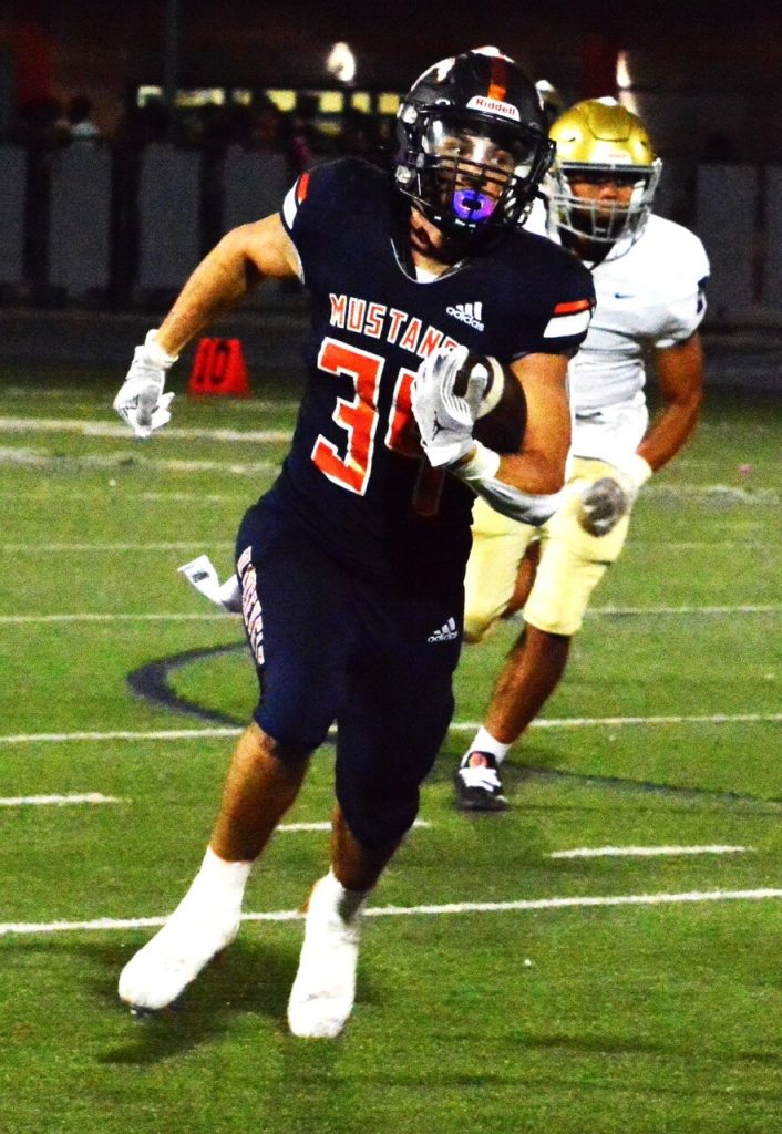 Eastvale Roosevelt’s Mitchell Rodenbaugh (34) looks at his blockers as he weaved his way to the end zone on a 62 yard touchdown run against the Riverside North.  The Mustangs blasted the Huskies 41 – 7.  
Credit: Photo by Gary Evans

