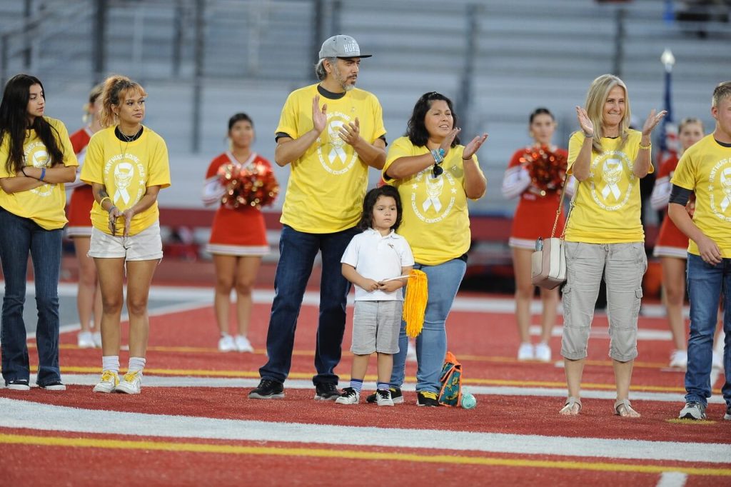 Wearing yellow shirts emblematic of childhood cancer awareness, parents and children take part in a pre-game ceremony before Corona hosted Pasadena Maranatha in a non-league varsity football game. Maranatha prevailed 48-13.
Credit: Photo by Jerry Soifer
