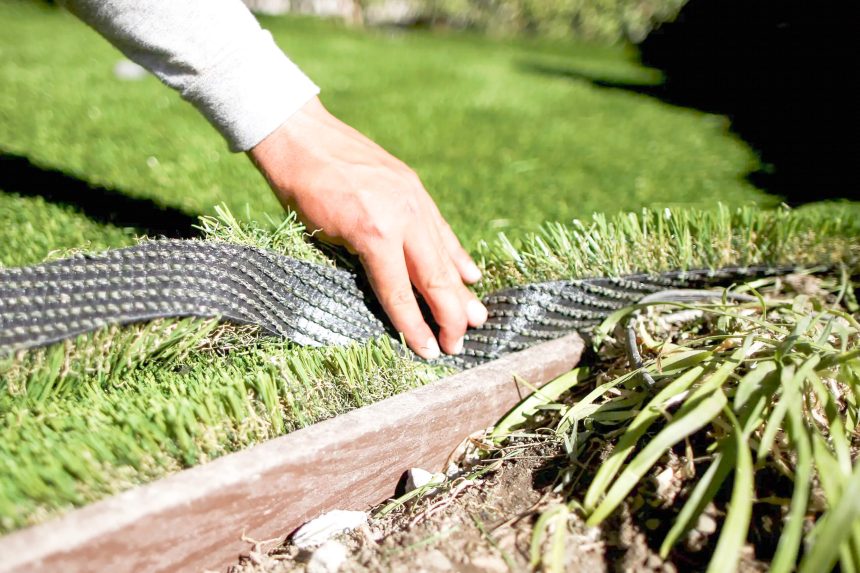 Workers install artificial turf in the yard of a home in Los Angeles in 2015. Credit: Photo by Lucy Nicholson, Reuters