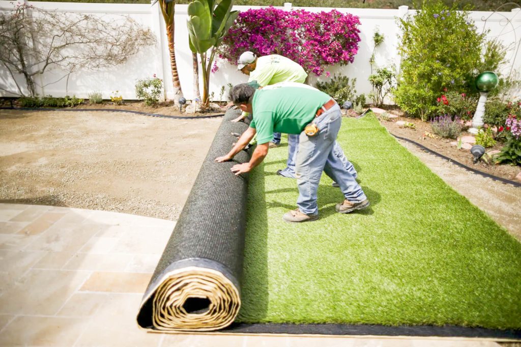 Synthetic Turf- Workers roll out artificial turf after digging up a lawn due to the drought, at a home in Laguna Niguel in 2015. 
Photo by Lucy Nicholson, Reuters
