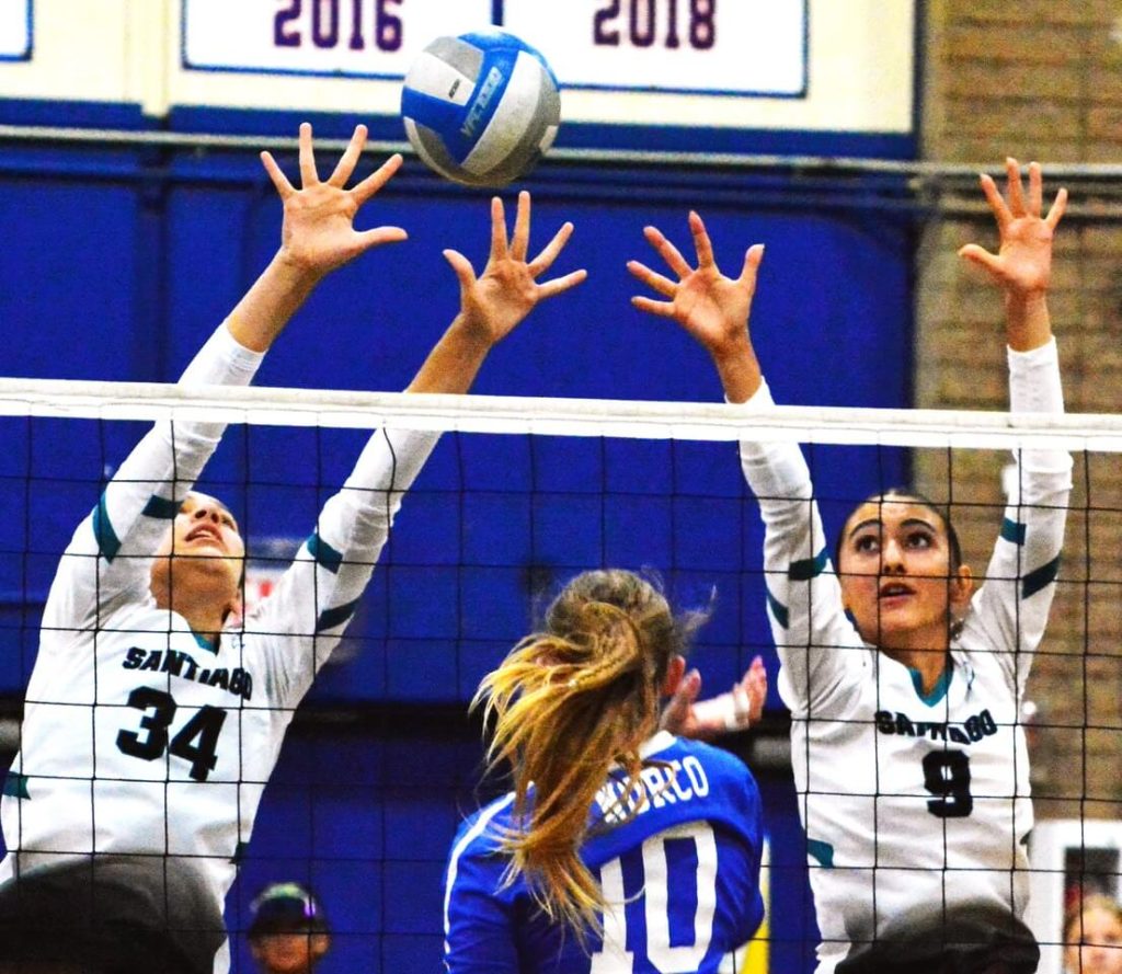 Corona Santiago’s Morgan Hermann (34) and Sarah Guzzetti (9) try to block Norco’s Jayden Franchere’s (10) tap over the net.  The Sharks took the first game, but the Cougars won the next three to claim the Big VIII League championship.
Credit: Photo by Gary Evans
