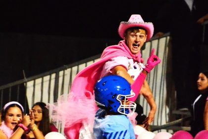 Norco Cougar Den student section leader Ryan Ibbetson (top) celebrates Tyler Riddle’s (center) touchdown catch giving Norco an early lead over Temecula Chaparral.