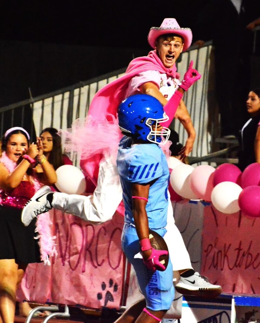 Norco Cougar Den student section leader Ryan Ibbetson (top) celebrates Tyler Riddle’s (center) touchdown catch giving Norco an early lead over Temecula Chaparral.