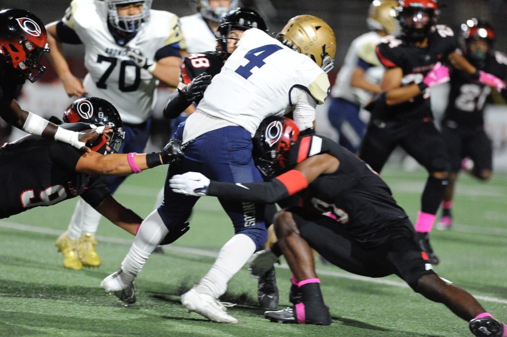 Vista Murrieta's Alexander Vega is sandwiched by Corona Centennial defenders in a conference game the Huskies dominated, 62-14. 
Credit: Photo by Jerry Soifer
