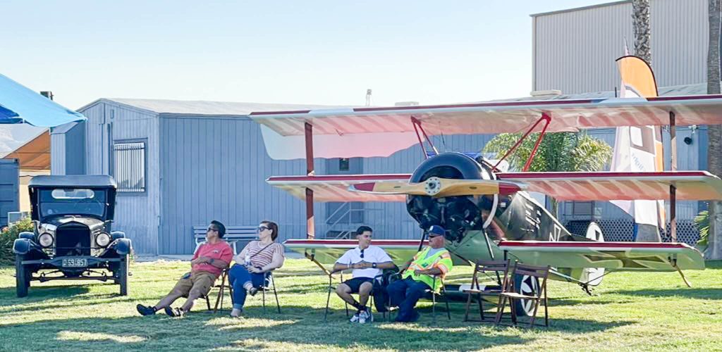 The wings of an antique triplane provided shade for birthday revelers to take in the history of the air field. 
Credit: Photo by Don Ray.
