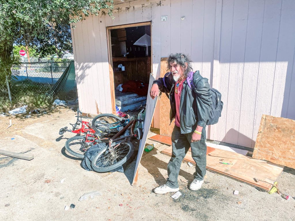 Eddie Cortez visits a friend who looks after his red bicycle when Eddie is on the streets.  Credit: Photo by Don Ray