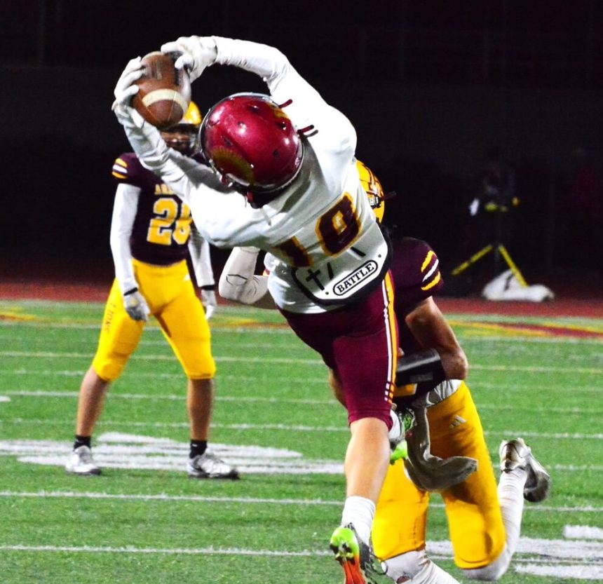 Hillcrest receiver Jacob Mcdowell (10) makes an incredible catch in front of Arlington’s Brodrick Buhr during the Trojans 31 – 21 victory over the Lions. The 2nd place finisher in the River Valley League, Hillcrest is at Linfield Christian in Temecula tonight in the first round of the Division 11 playoffs. Credit: Photo by Gary Evans