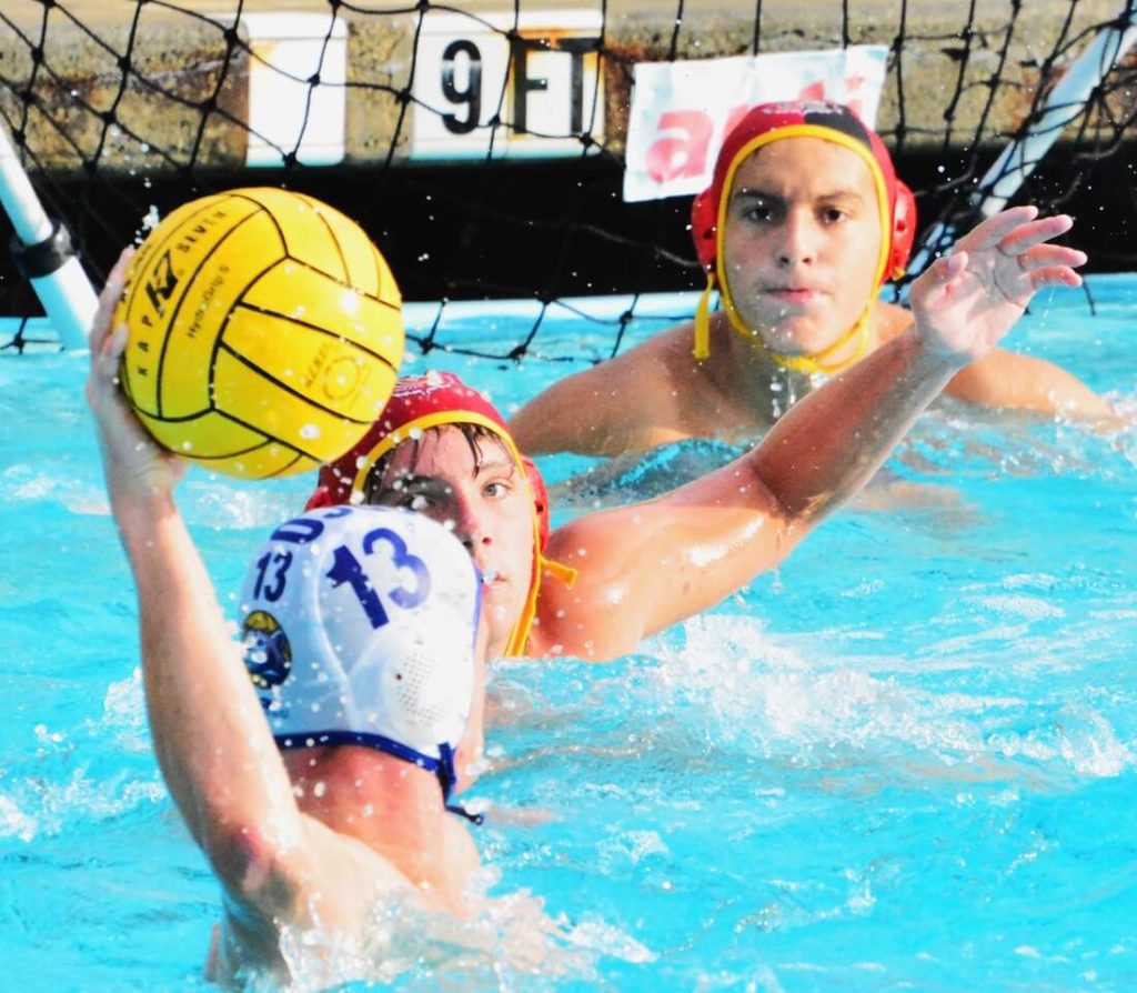 Norco’s Luke Ibbetson (13) aims at goal while Corona’s Adam Kirkpatrick (middle) and goalie Noah Olguin (top) ready to block. The Panthers nipped the Cougars 12 – 11 in a see saw match. Photo by Gary Evans