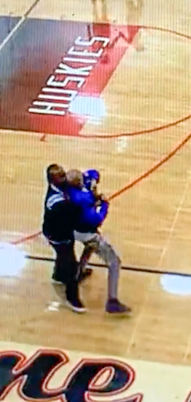 Basketball Game Attack. CalhounThe man identified as suspect Thaddis Lamont Brooks, (in blue) is wrestled away from the conflict. He is accused of inflaming the incident by punching several female high school athletes, before allegedly threatening students with a gun in the Centennial parking lot. Credit: NFHS