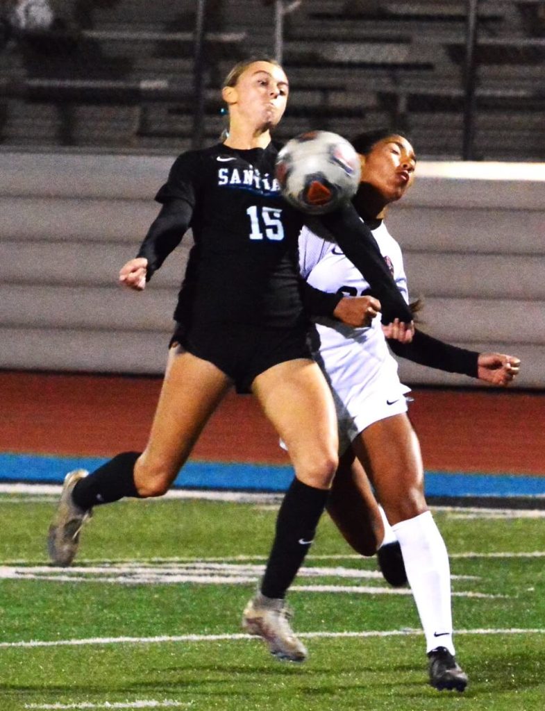 Featured Photos 12-15-2023. Corona Santiago’s Alexis Coughlin (15) battles a Downey player for the ball during the Sharks 5 – 0 throttling of the Vikings.