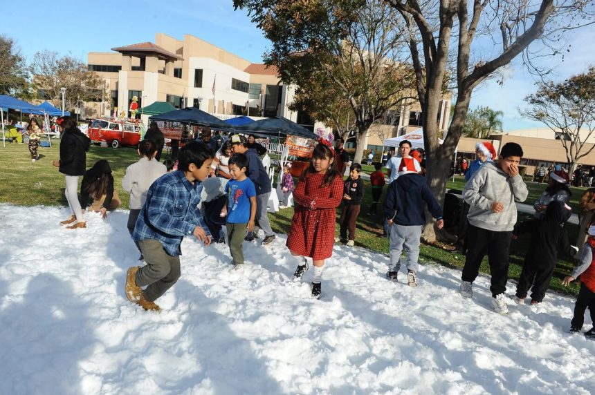 Some of the more than 1,000 boys and girls who registered for the Corona Cops and Kids play in the snow at the Corona Civic Center Saturday. Organized by the Corona Police Department at-need children were presented with holiday gifts. More Photos, back page. Credit: photo by Jerry Soifer