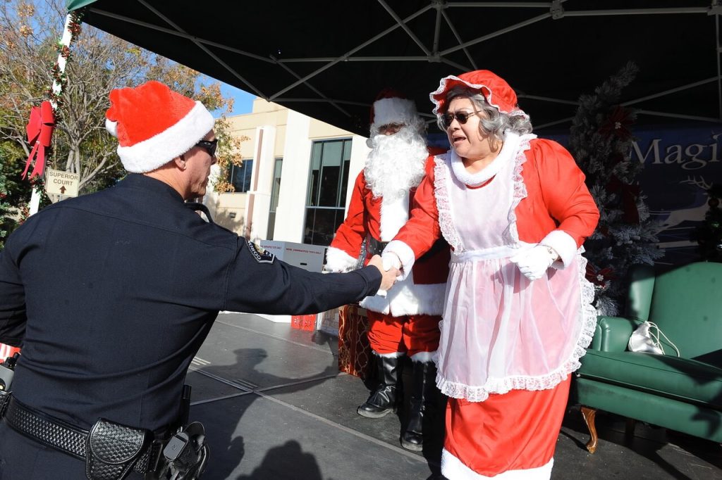 Corona Police Chief Bob Newman exchanges holiday wishes with Mrs. Claus, (CNUSD Board Member Mary Helen Ybarra) and Santa (Oscar Figari). 