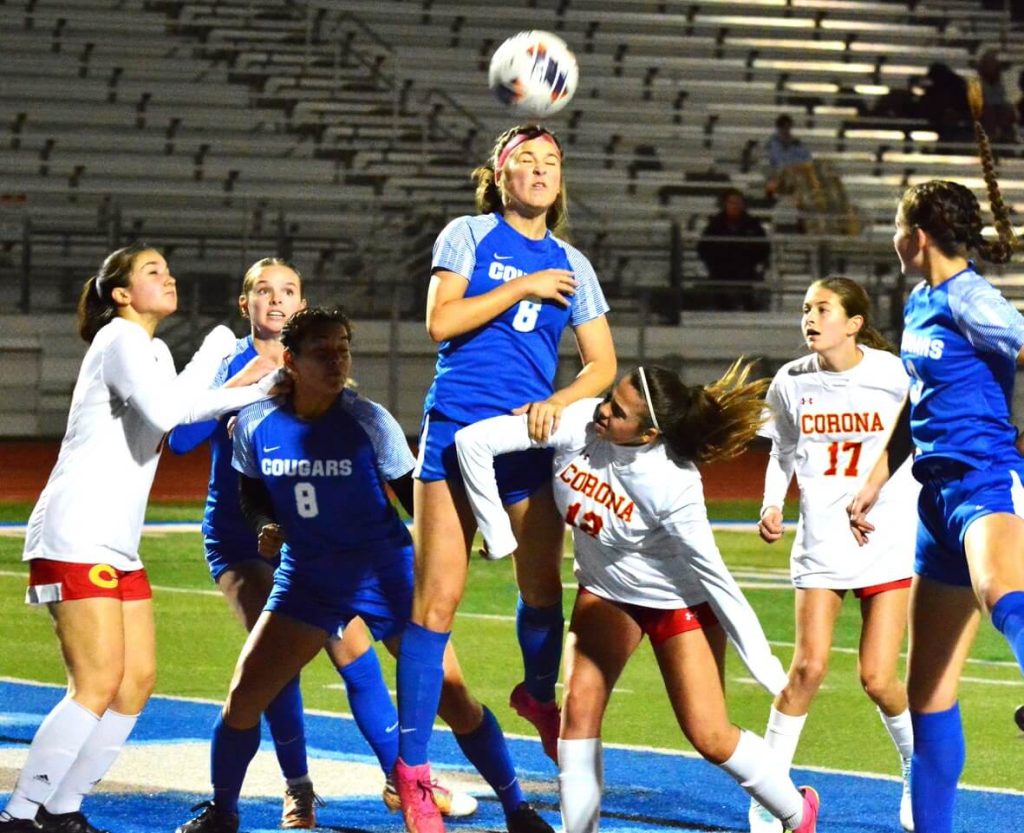 Norco’s Ashlee Abellana (6) heads the ball off a corner kick while left to right Corona’s Delaney Prado (14), Norco’s Jaylin Young (5), Karen Pedraza (8), Corona’s Aua Cruz (12), Leah Walker (17), and Norco’s Emmalee Snow (3) watch.  The Cougars defeated the Panthers 2 – 0. 
Credit: Photo by Gary Evans
