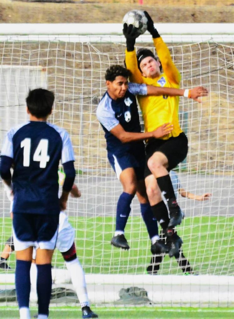 Citrus Hill’s Jose De La Torre (8) and Norco goalie Diego Salgado (right) collide late in the second half of the Winter Classic Blue Division championship game. The Cougars were holding onto a 1 – 0 lead. Salgado hung on to the ball after crashing to the turf, and Norco added another goal to beat the Hawks 2 – 0. Christian Ibarra (14) watches the action.