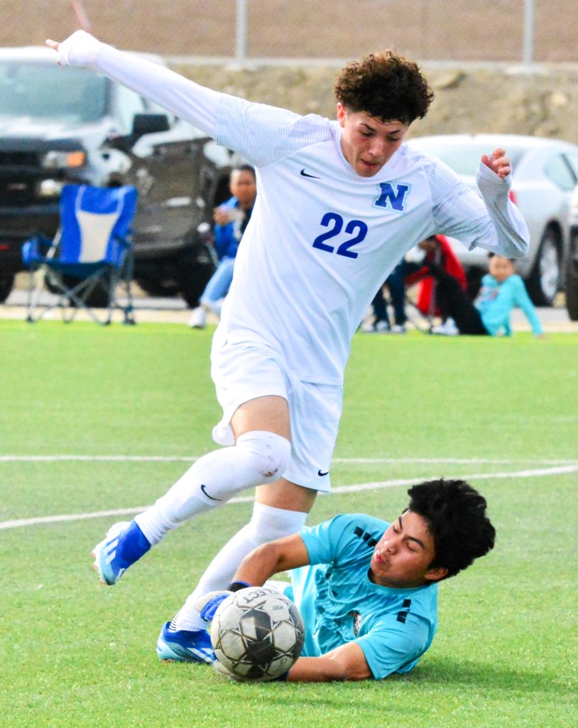 Norco’s Jacob Vega (22) gets past Citrus Hill goalie Elvin Vargas (right) during the first half of the Winter Classic Orange Division Championship game. Vega later scored the Cougars first goal, and Abraham Garcia blasted in the insurance goal as Norco downed the Hawks 2 – 0.