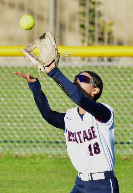 Heritage’s Lizette Perez (18) fights the sun to make a catch in centerfield. 