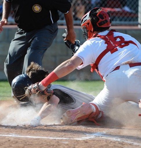 Corona catcher Josh Springer tags out Corona Santiago's Logan Clear at home plate in a Big VIII League game at Corona. The Panthers won, 11-3.
