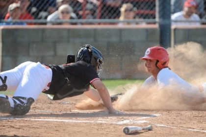 Corona's Billy Carlson beats the tag of Corona Centennial catcher Michael Nonis to score one of his team's runs in a 2-0 victory Friday in a game that clinched the Big VIII League title for the Panthers. Credit: Photo by Jerry Soifer