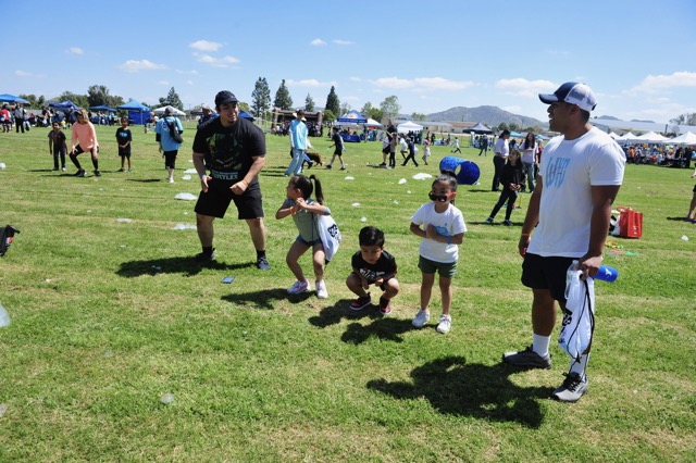 Adults encourage children to exercise at an event to promote healthy kids at the Corona-Norco YMCA and Auburndale Intermediate School on Saturday.