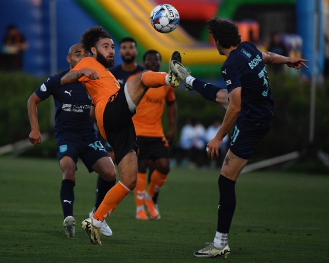 The Orange County Soccer Club's Makrus Nakkim and Monterey Bay's Chase Boone each high foot the soccer ball in a USL match at the Great Park in Irvine on Saturday. Orange County won, 2-0.