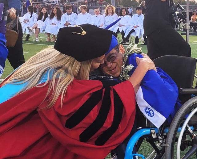 Featured Photos 06-07-2024. Norco High Principal Dr. Melissa Bako hugs JR Brunmier after he rolled down the ramp after receiving his diploma during the Class of 2024’s Commencement exercises last Wednesday at the school.